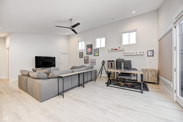 living room with radiator, light hardwood / wood-style floors, high vaulted ceiling, and ceiling fan