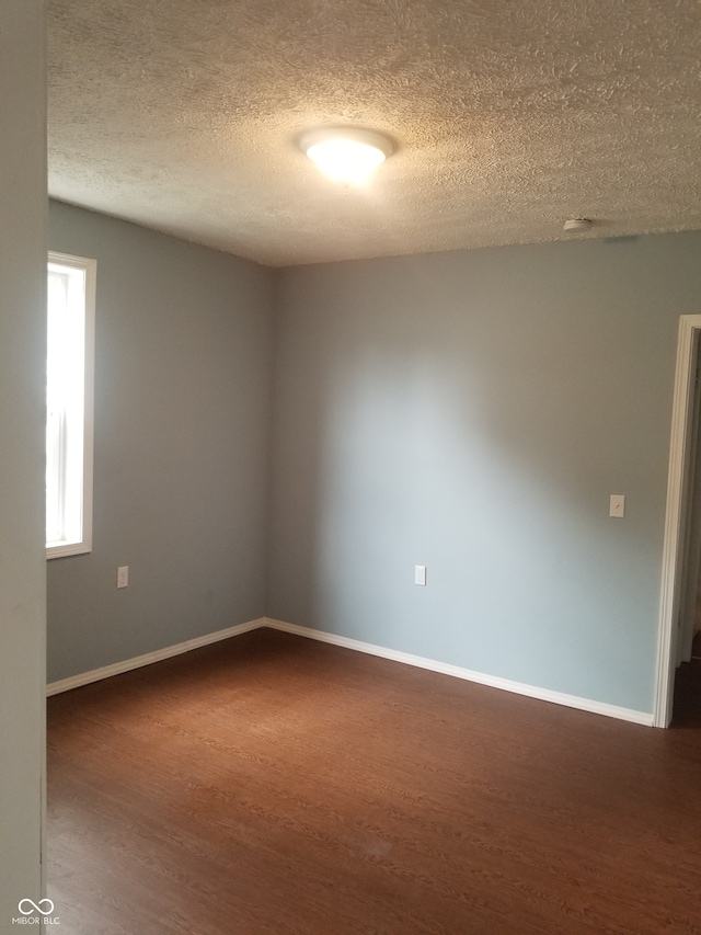 unfurnished room featuring hardwood / wood-style floors and a textured ceiling