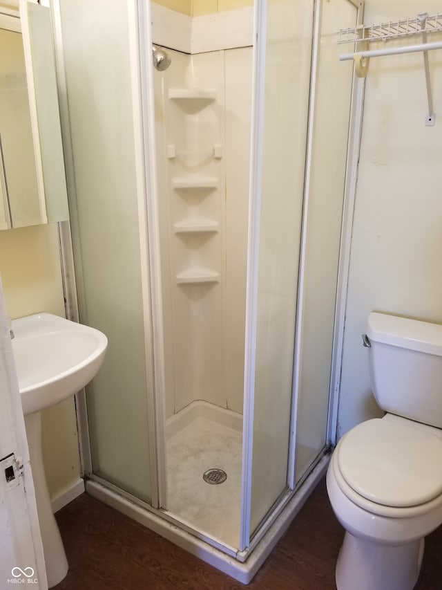 bathroom featuring hardwood / wood-style floors, toilet, and walk in shower