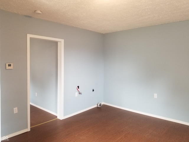 spare room with a textured ceiling and dark hardwood / wood-style floors