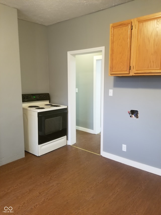 kitchen featuring white electric range oven, dark hardwood / wood-style flooring, a textured ceiling, and light brown cabinetry