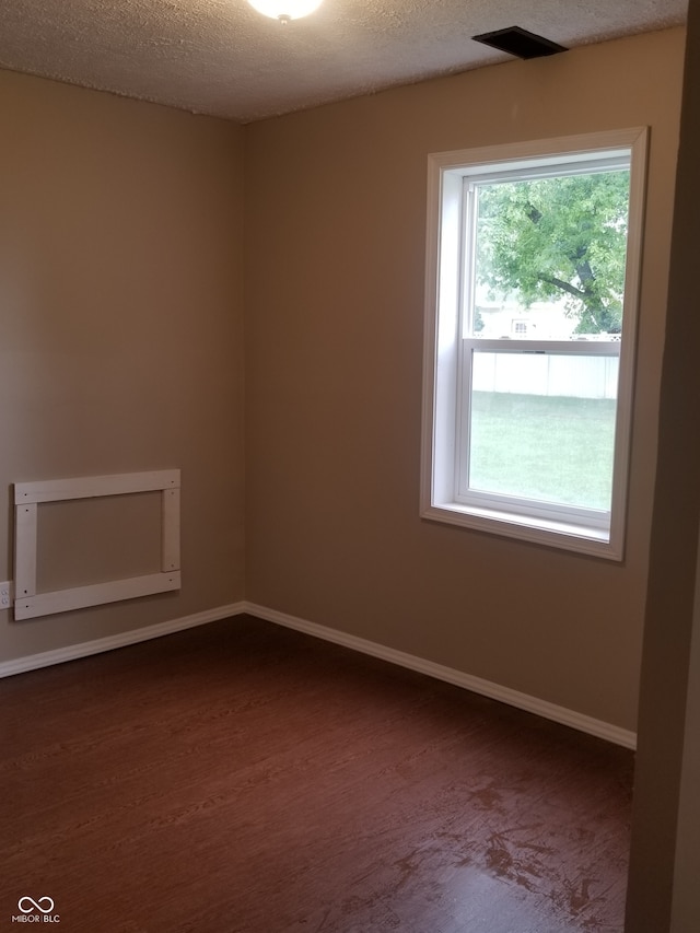 unfurnished room with a textured ceiling and hardwood / wood-style flooring