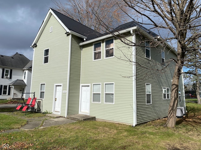 back of property featuring a lawn