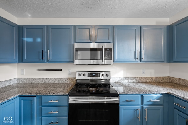 kitchen with blue cabinetry, a textured ceiling, and stainless steel appliances