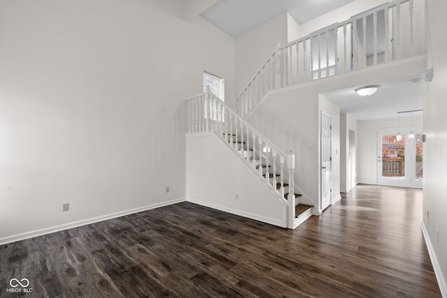 entryway with a high ceiling, dark hardwood / wood-style floors, and an inviting chandelier