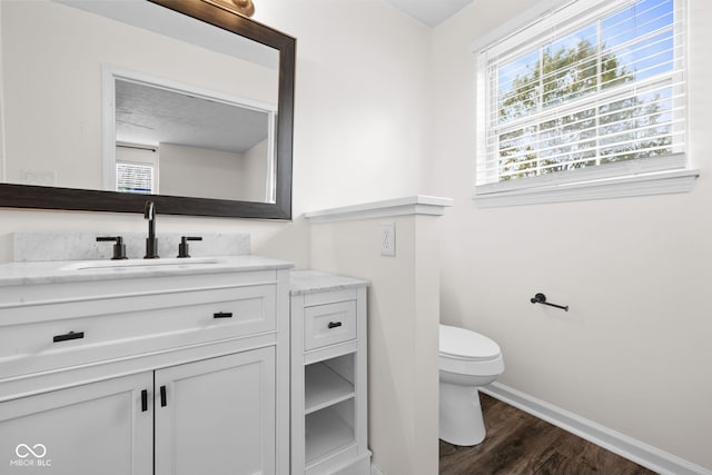 bathroom with hardwood / wood-style floors, vanity, and toilet