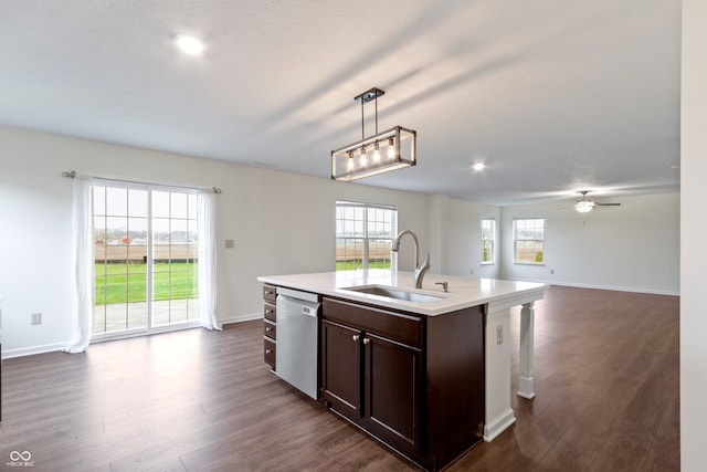 kitchen with a wealth of natural light, a center island with sink, hanging light fixtures, and sink