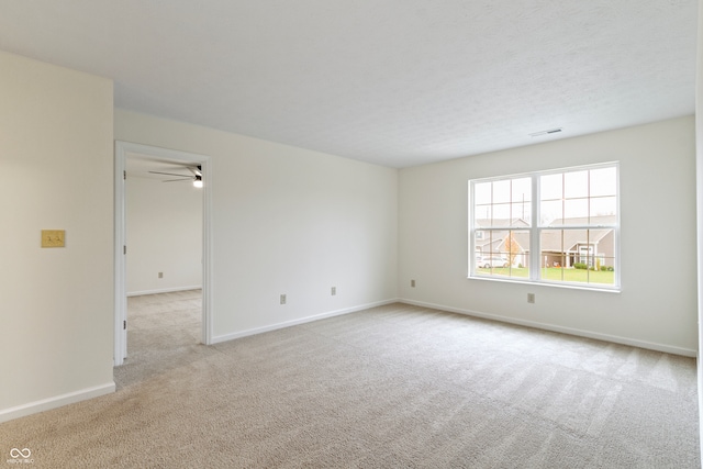 empty room featuring light colored carpet and ceiling fan