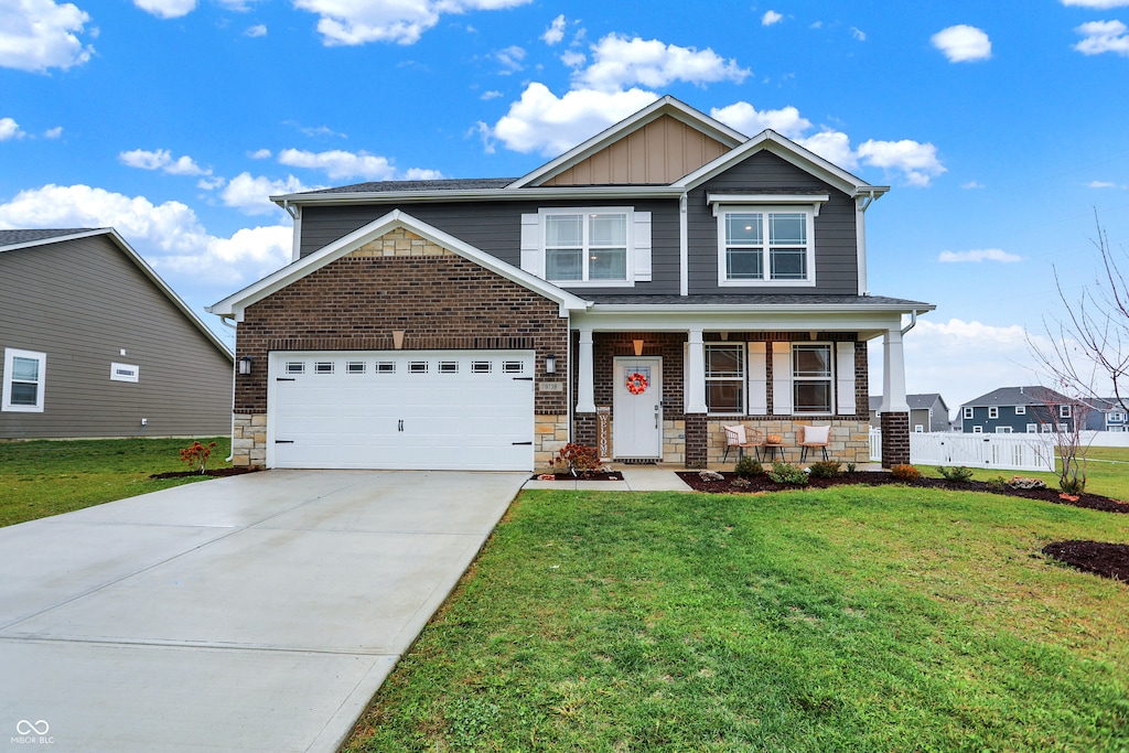 craftsman house with a porch, a front yard, and a garage