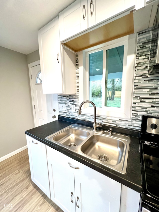 kitchen featuring light hardwood / wood-style floors, sink, white cabinetry, and backsplash