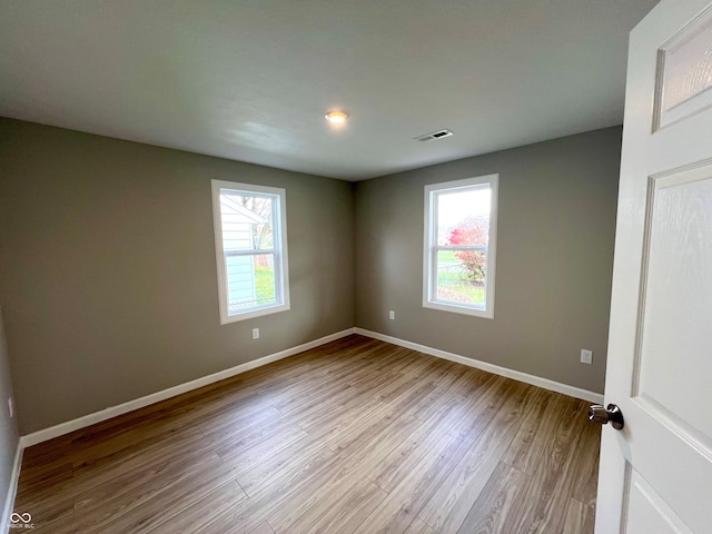 spare room with light hardwood / wood-style floors and a wealth of natural light