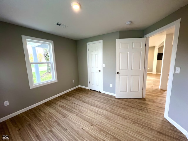 unfurnished bedroom with a closet and light hardwood / wood-style floors