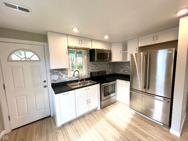 kitchen featuring white cabinets, stainless steel appliances, a healthy amount of sunlight, and sink