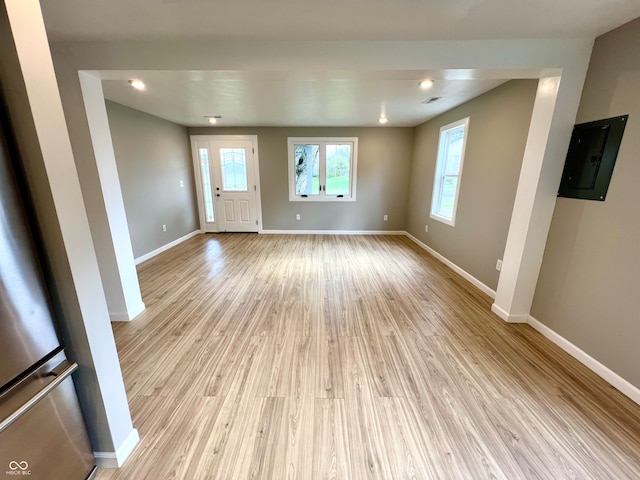 unfurnished living room featuring electric panel and light hardwood / wood-style flooring