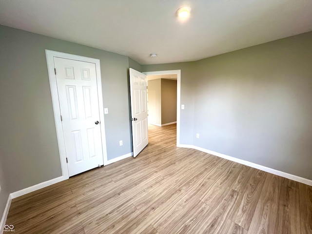 unfurnished bedroom featuring light wood-type flooring and a closet