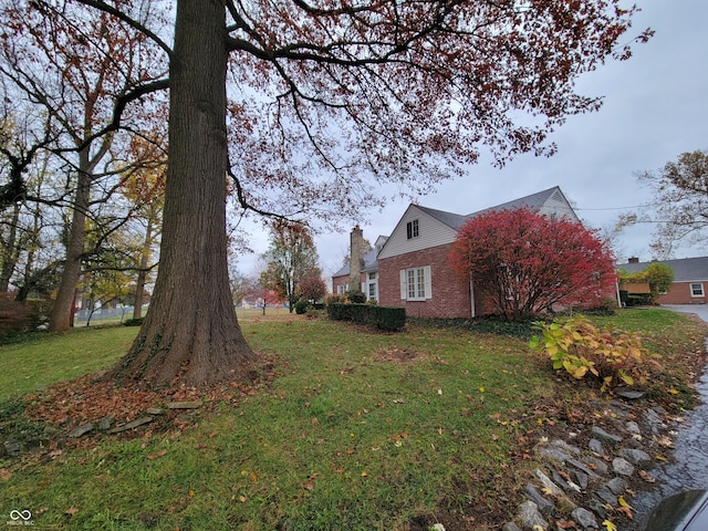 view of side of home with a yard