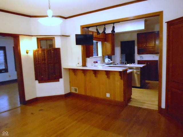 705 W 6th St, Seymour, IN 47274 - kitchen with dishwasher, light wood-style flooring, a breakfast bar area, light countertops, and ornamental molding