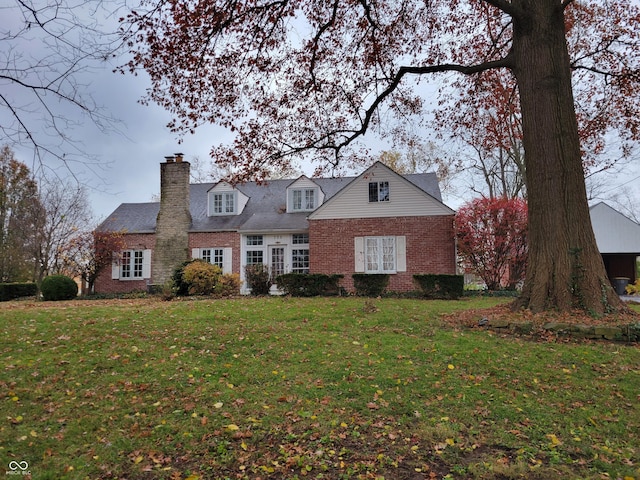 705 W 6th St, Seymour, IN 47274 - cape cod-style house featuring brick siding, a front yard, and a chimney