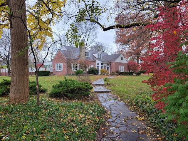 705 W 6th St, Seymour, IN 47274 - view of front of house with brick siding, a chimney, and a front lawn