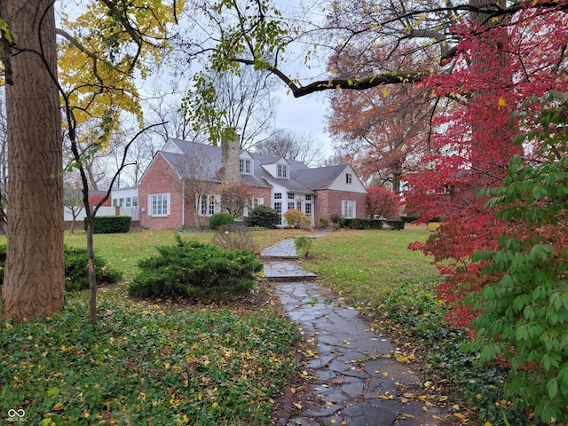 705 W 6th St, Seymour, IN 47274 - new england style home with a chimney, a front lawn, and brick siding