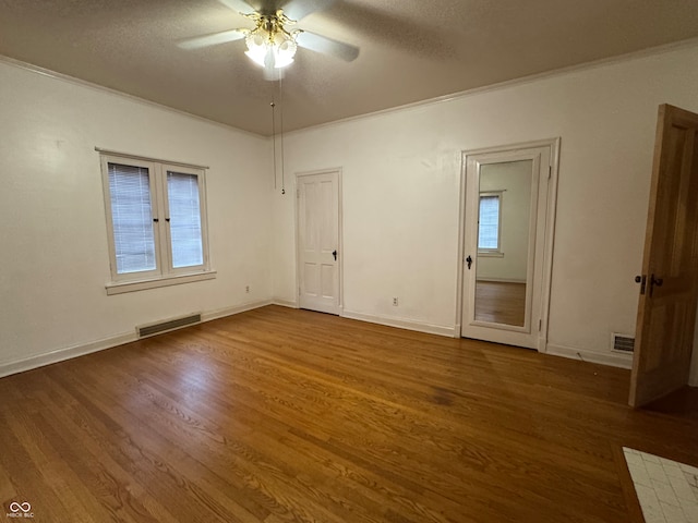 interior space featuring a textured ceiling, dark hardwood / wood-style floors, ceiling fan, and ornamental molding