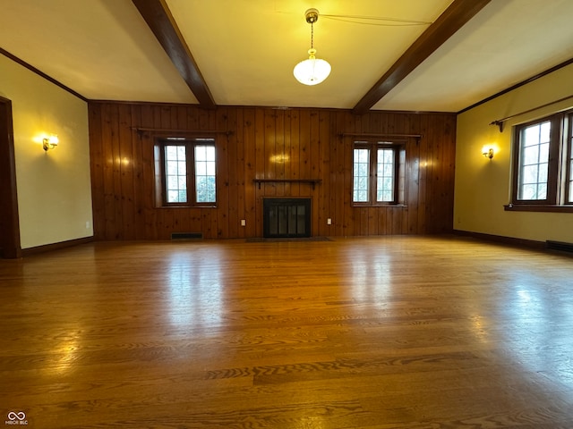 unfurnished living room with hardwood / wood-style floors, beamed ceiling, and a healthy amount of sunlight