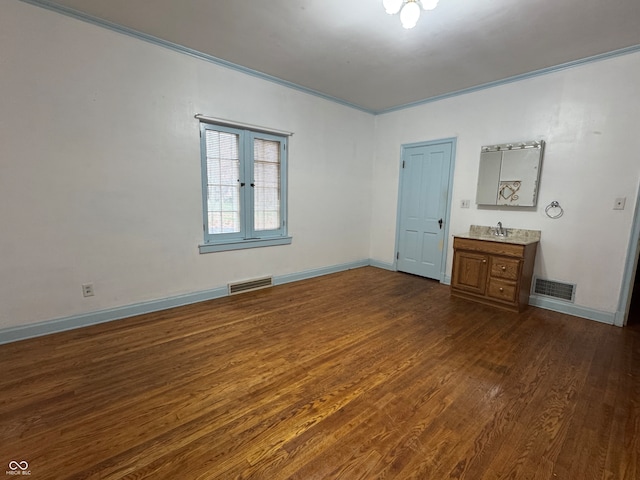 unfurnished bedroom featuring dark hardwood / wood-style flooring, ornamental molding, and sink