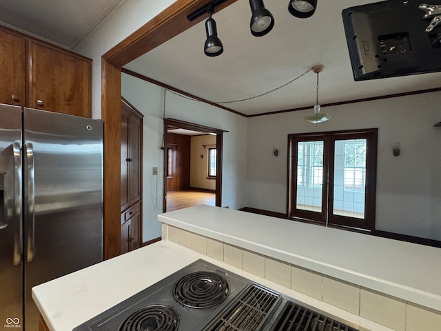 kitchen featuring hardwood / wood-style flooring, kitchen peninsula, crown molding, and stainless steel refrigerator