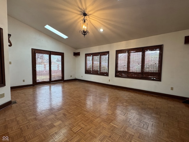 spare room with parquet flooring, a skylight, and high vaulted ceiling