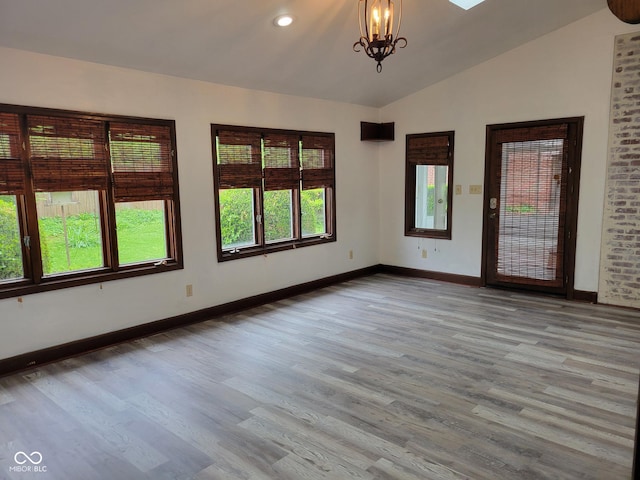 705 W 6th St, Seymour, IN 47274 - spare room featuring baseboards, lofted ceiling, a chandelier, wood finished floors, and recessed lighting