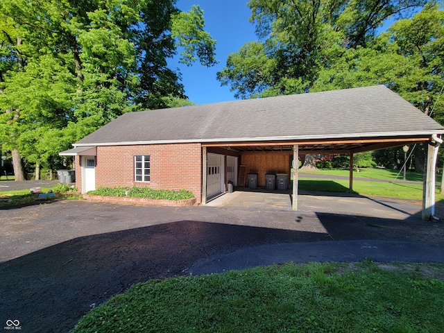 705 W 6th St, Seymour, IN 47274 - view of side of property featuring an outbuilding, brick siding, a yard, a carport, and driveway