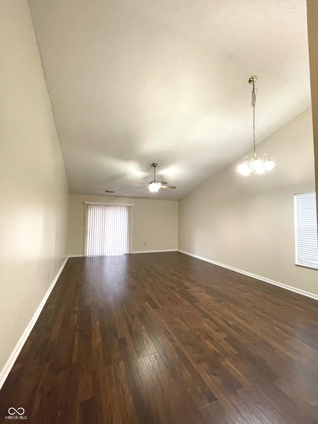 unfurnished room with a textured ceiling, dark hardwood / wood-style floors, lofted ceiling, and ceiling fan with notable chandelier