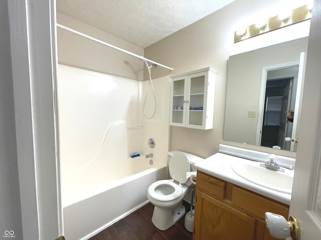 full bathroom featuring vanity, a textured ceiling, shower / washtub combination, hardwood / wood-style flooring, and toilet