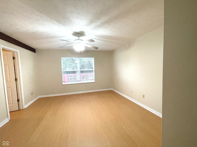 spare room with ceiling fan, light hardwood / wood-style floors, and a textured ceiling