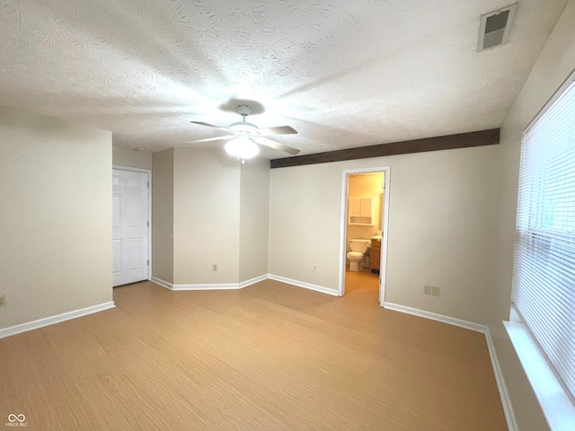 empty room with a textured ceiling, light hardwood / wood-style flooring, and ceiling fan