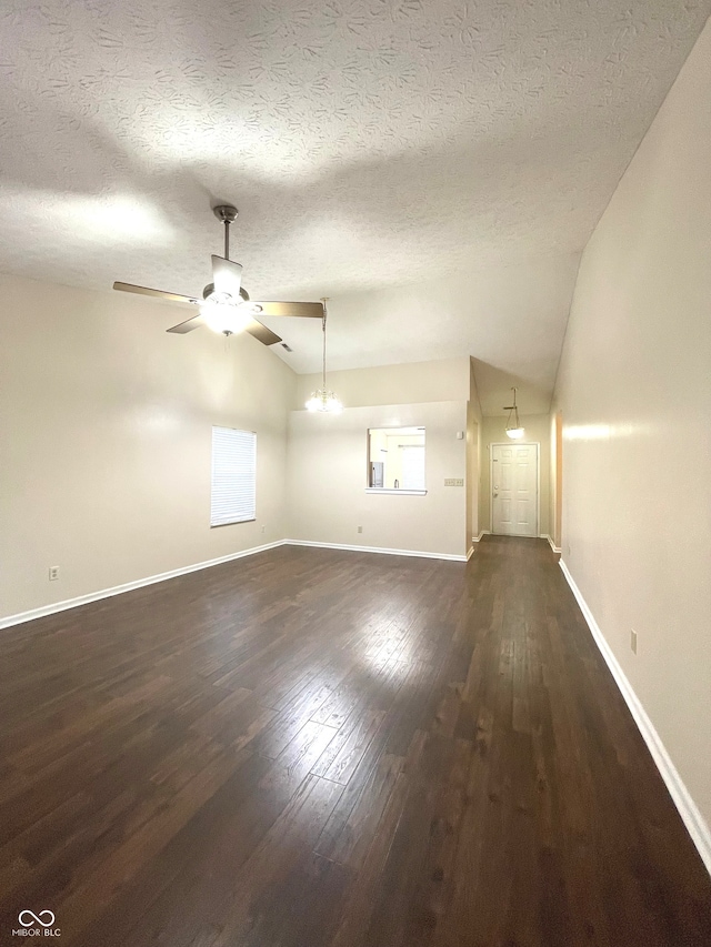 unfurnished living room featuring dark hardwood / wood-style flooring, a textured ceiling, and vaulted ceiling