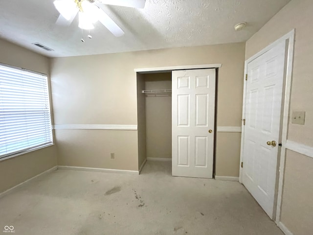 unfurnished bedroom with ceiling fan, a textured ceiling, and a closet