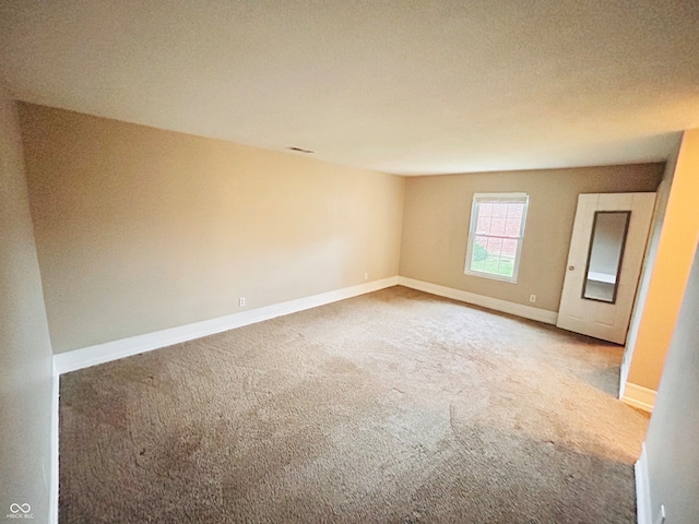 unfurnished room featuring carpet flooring and a textured ceiling