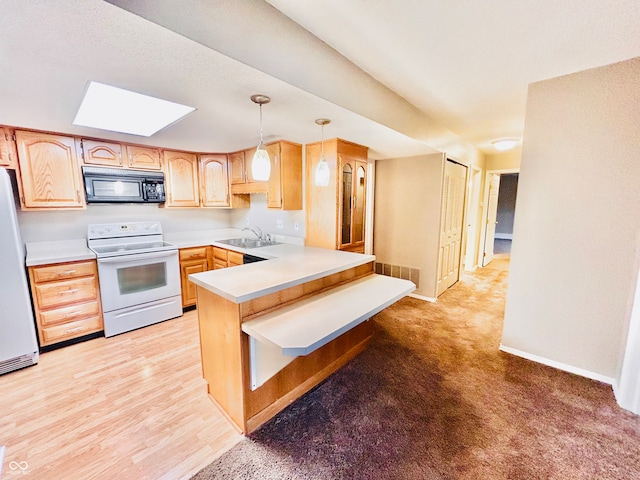 kitchen featuring white appliances, sink, light brown cabinetry, decorative light fixtures, and kitchen peninsula