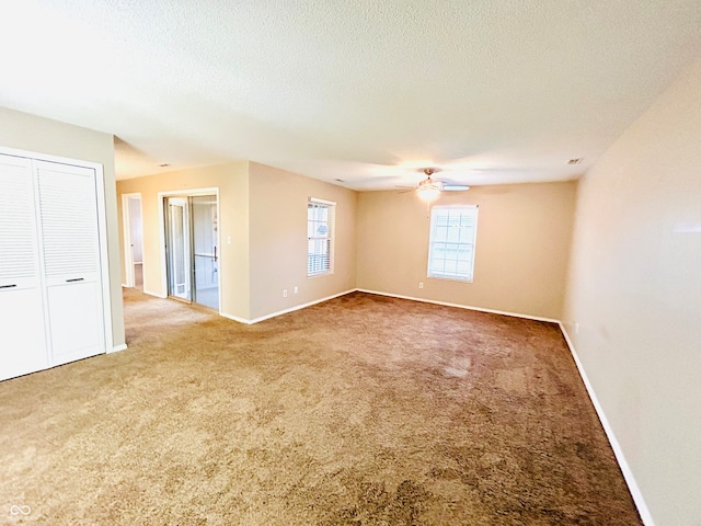 empty room featuring carpet, a textured ceiling, and ceiling fan