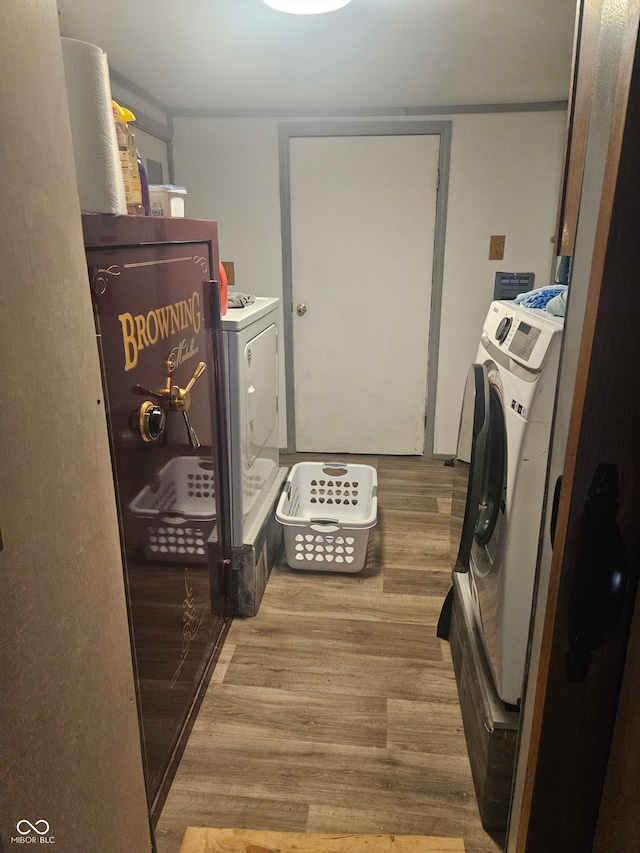 laundry area featuring washing machine and dryer and light hardwood / wood-style floors