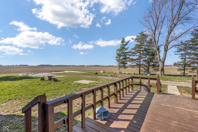 wooden terrace featuring a yard and a rural view