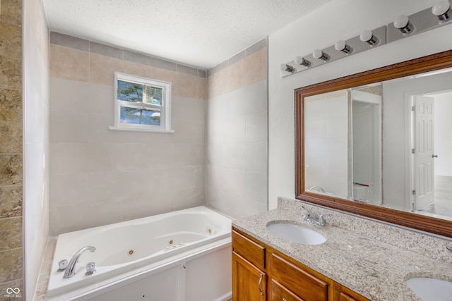 bathroom featuring vanity, a textured ceiling, and a bathtub