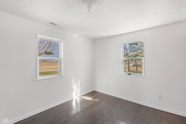 unfurnished room with dark hardwood / wood-style flooring