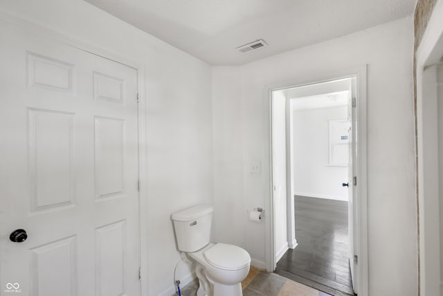 bathroom featuring hardwood / wood-style flooring and toilet