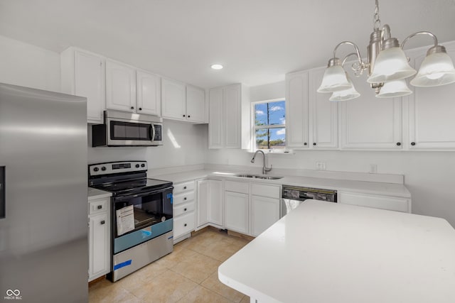 kitchen with appliances with stainless steel finishes, white cabinetry, hanging light fixtures, and sink