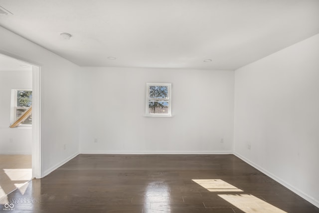 empty room with dark hardwood / wood-style flooring