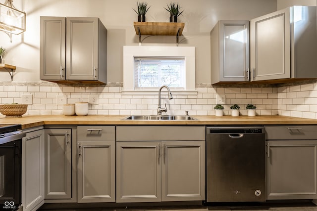 kitchen featuring gray cabinetry, dishwasher, wooden counters, and sink