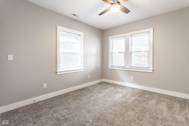 spare room featuring carpet, ceiling fan, and a wealth of natural light