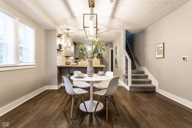 dining area featuring a textured ceiling and dark hardwood / wood-style floors